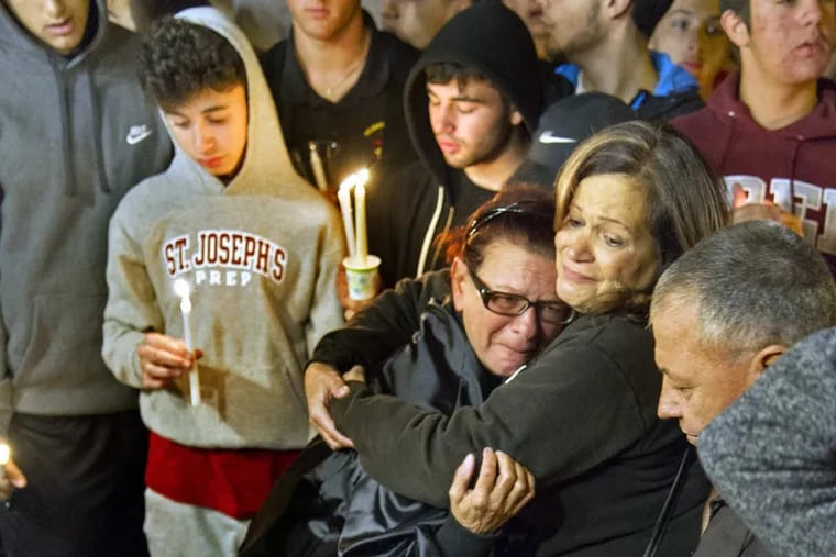 Friends and classmates join the family of Salvatore DiNubile, a St. Joseph’s Prep student who was fatally shot Tuesday night, at a Wednesday night vigil. A Mastery Charter School student, Caleer Miller, also was killed in the shooting, for which no motive has been established.