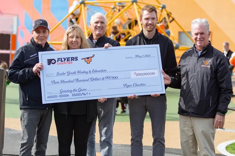 Scott Tharp, from left, Cindy Stutman, Dan Hilferty, Sean Couturier, and Bill Whitmore present a check for a Learn to Play program at the ribbon cutting ceremony for the outdoor street hockey rink at the Joseph Scanlon Recreation Center on Monday, May 1, 2023.