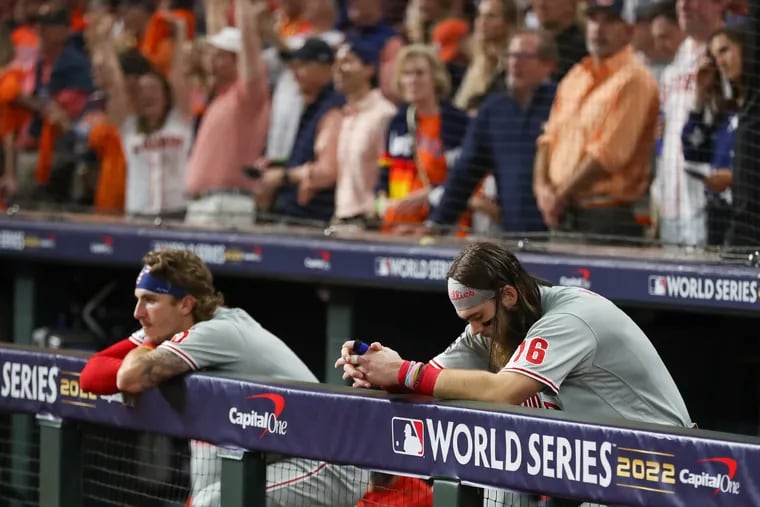 Dejected Phillies Bryson Stott (left) and Brandon Marsh in the dugout after the Astros won the World Series Saturday night.