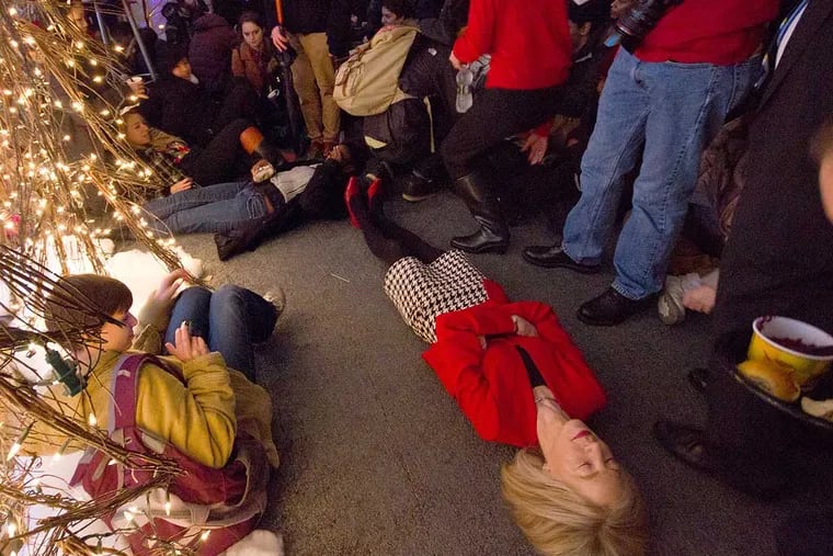University of Pennsylvania President Amy Gutmann joins protesters in a 'die-in' at a holiday party at her home. Photo credit: Luke Chen, The Daily Pennsylvanian