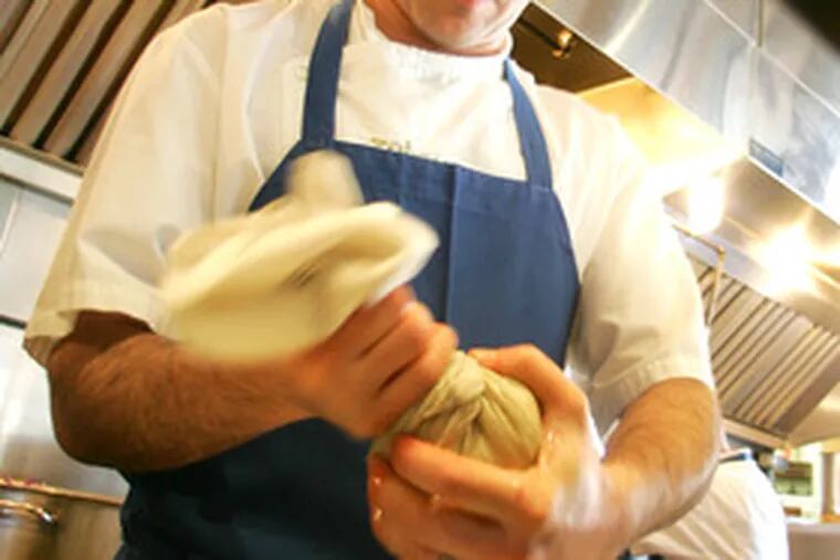 At Zahav, chef-owner Michael Solomonov squeezes moisture from grated potatoes.