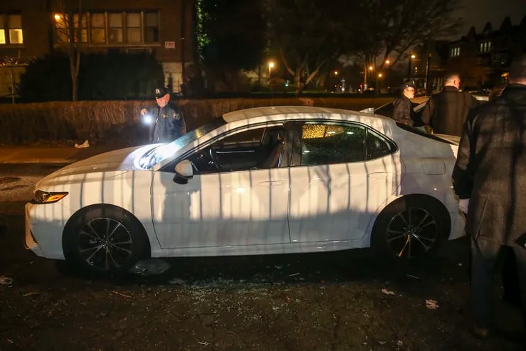 Crime scene unit looks over a car that was occupied by an undercover police sergeant when she was attacked by a man who shattered the driver-side window with a large object in the Hunting Park area near Broad Street, Tuesday, February 4, 2020.