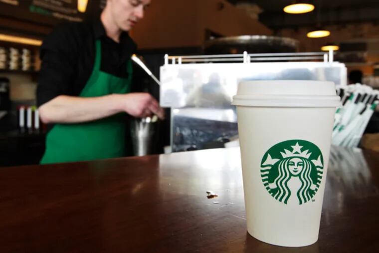 FILE - In this Friday, April 27, 2012, photo, a Starbucks drink waits for a customer to pick it up as barista Josh Barrow prepares another.  (AP Photo/Ted S. Warren, File)
