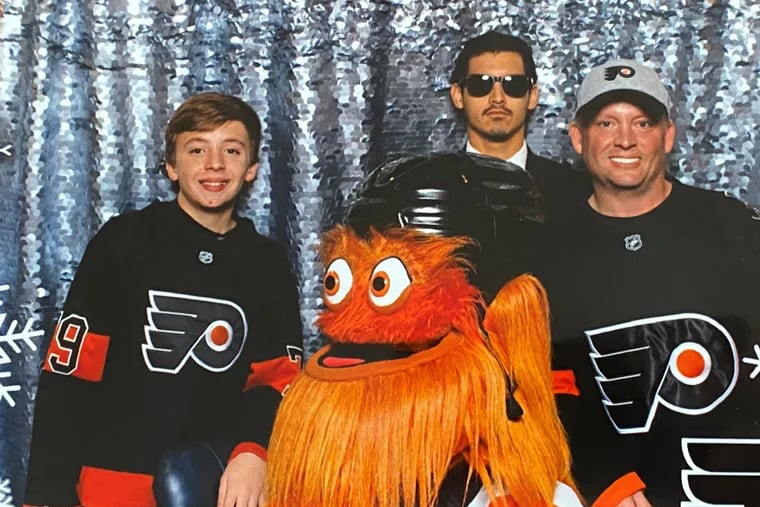 Gritty poses for a picture with Brandon Greenwell (left) and his father, Chris, during a Nov. 19 event at the Wells Fargo Center. Chris Greenwell claims Gritty punched Brandon in the back after the picture was taken, though Comcast Spectacor says there is no video footage of the incident.