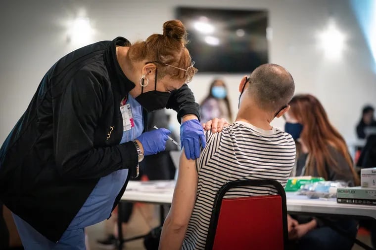 A member of the Health Department Clinic Staff administers the vaccine at a clinic at the Grand Yesha Ballroom in South Philadelphia.