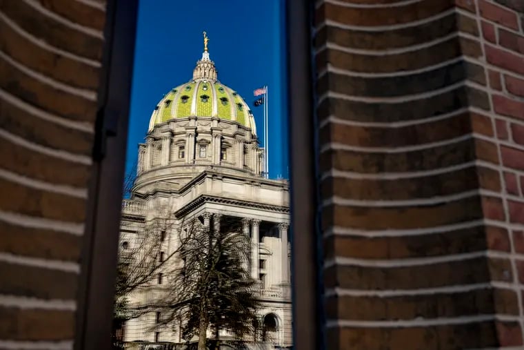 The 1906 state capitol building in Harrisburg is reflected in the windows of an office building on North Third Street.