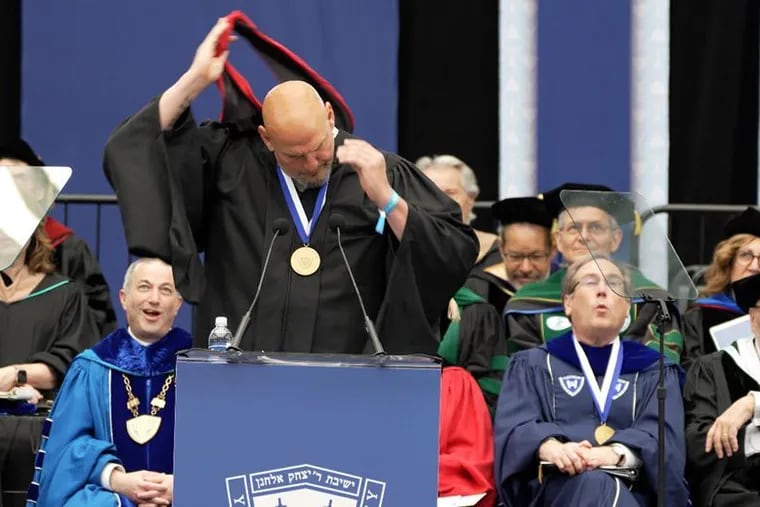 Senator John Fetterman removes his Harvard Kennedy School masters graduation hood at the Yeshiva University commencement on May 29, 2024.
