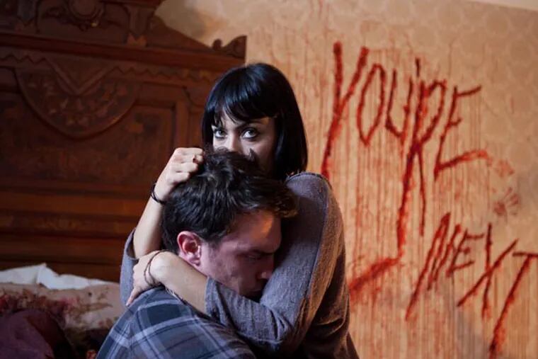 This film publicity image released by Lionsgate shows Nick Tucci and Wendy Glenn, right, in a scene from "You're Next."  (AP Photo/Lionsgate, Corey Ransberg)