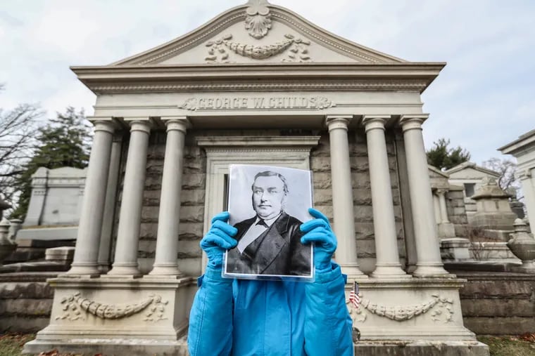 Pattye Stringer, a guide at Laurel Hill Cemetery, stands before the George W. Childs mausoleum, in the cemetery, and holds up a picture of George W. Childs, the past editor and owner of The Public Ledger newspaper in Philadelphia in the 1800s.