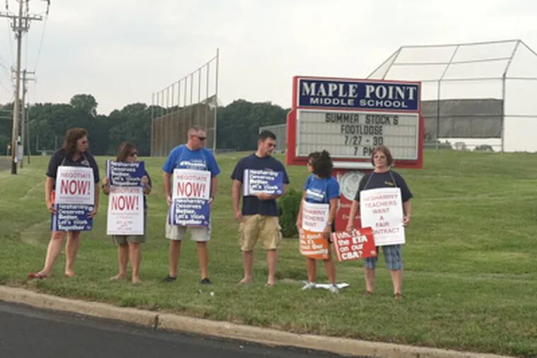 Some of the approximately 50 demonstrators hold signs at an entrance to Neshaminy Middle School on Monday evening. (Bill Reed / Staff)