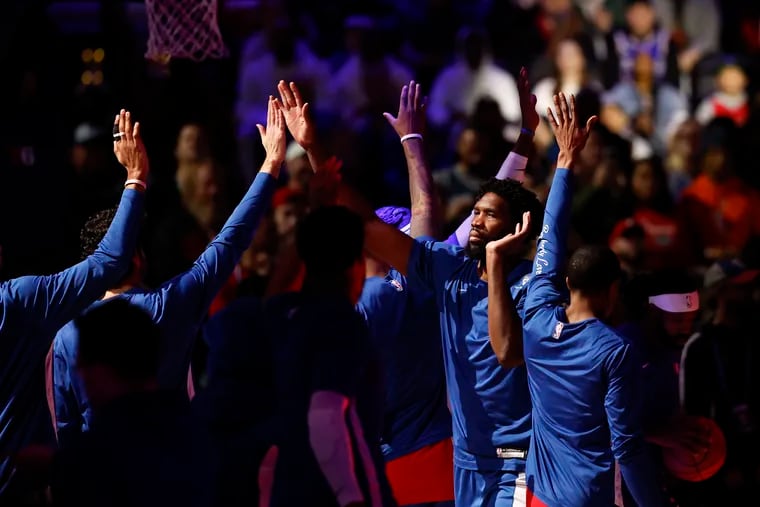 Sixers center Joel Embiid high-fives his teammates during player introductions before the Sixers played the Detroit Pistons on Dec. 15.
