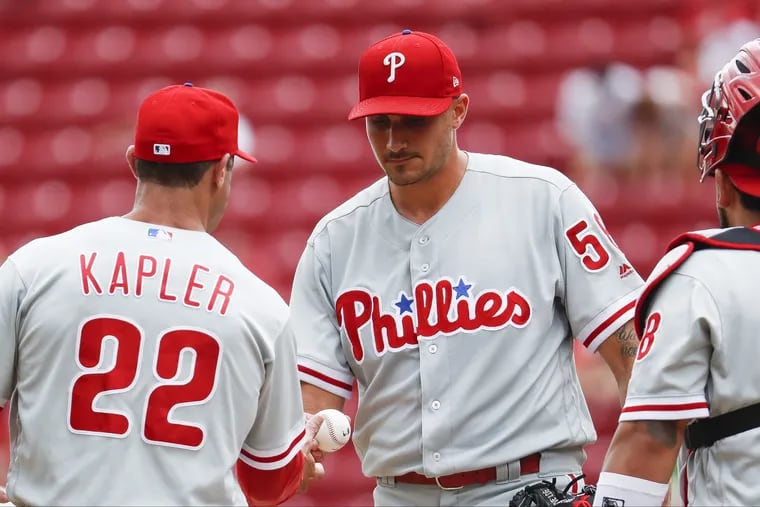 Phillies starter Zach Eflin hands the ball to Gabe Kapler as he is pulled in the sixth inning against the Reds.