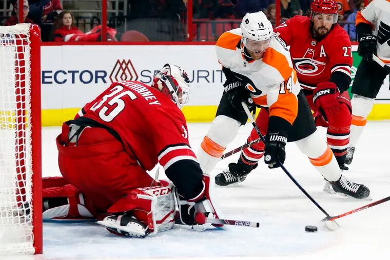 Sean Couturier attempts a shot on Carolina goaltender Curtis McElhinney during the second period of the Flyers' 3-1 loss to the Hurricanes Monday. (Karl B DeBlaker / AP Photo)