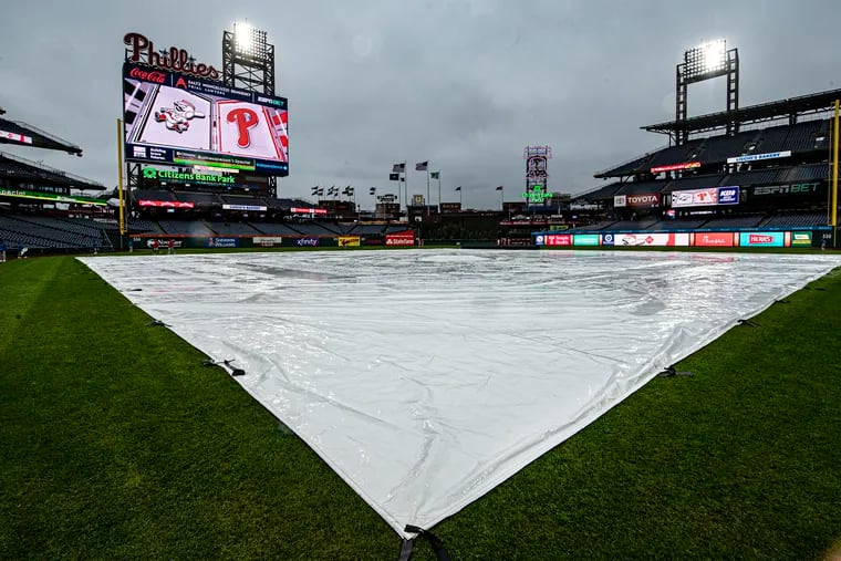 A tarp covers the field during a lengthy rain delay before the Cincinnati Reds played the Phillies on Wednesday at Citizens Bank Park.
