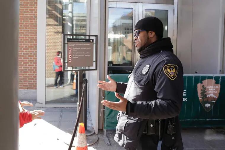 A Sector Protective Services security guard at the  Liberty Bell Center in Independence National Historical Park in Phila., Pa. informs visitors that the building is closed because of the US government shutdown on Jan. 20, 2017.