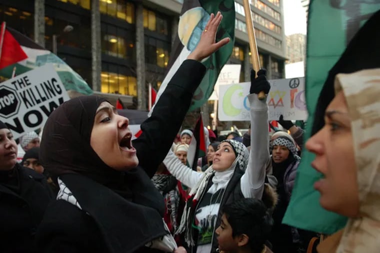 Demonstrators shout pro-Palestinian slogans yesterday outside the Israeli Consulate in the 1800 block of JFK Boulevard.