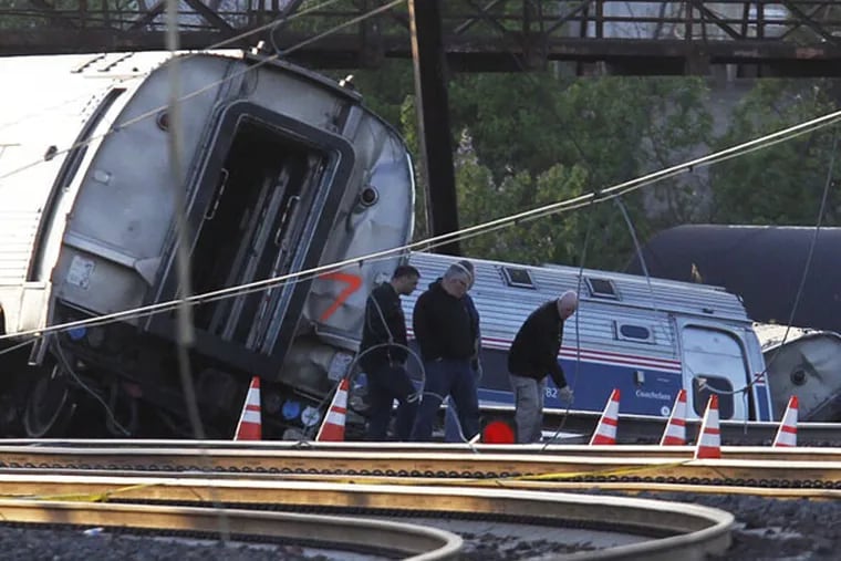 Investigators examine the derailment scene Wednesday morning, hours after the fatal Amtrak derailment.