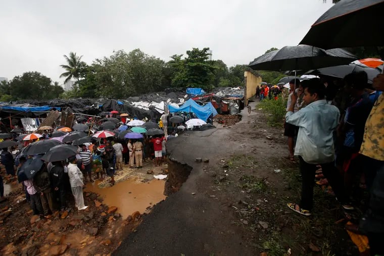 Rescuers and others gather at the spot after heavy rainfall caused a wall to collapse onto shanties, in Mumbai, India, Tuesday, July 2, 2019. More than a dozen people were killed even as forecasters warned of more rains.