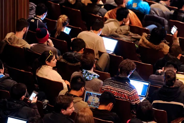 Laptops and smart phones fill the audience during the finals of the PennApps January 18, 2015 in U.Penn's Irvine Auditorium. TOM GRALISH / Staff Photographer