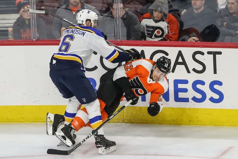 The Flyers' Michael Raffl gets checked by the Blues' Joel Edmundson during the third period.