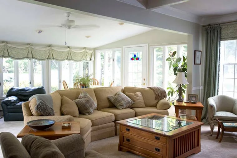 The living room , where upholstered couches and chairs fill a naturally lit space. ED HILLE / Staff Photographer