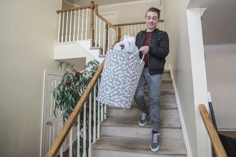 Anthony Scarpone-Lambert carries his laundry down the stairs from his bedroom to return for the spring semester at Penn. MICHAEL BRYANT/ Staff Photographer