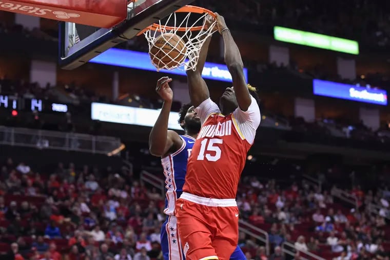 Houston Rockets center Clint Capela (15) dunks as Sixers center Joel Embiid watches during the first half of Friday's game at the Toyoto Center. The Sixers had a lackluster defensive effort.