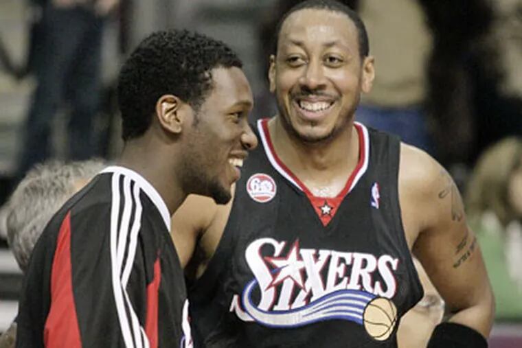 Sixers Donyell Marshall (8) and Royal Ivey, left, smile on the bench after Marshall hit a three-point shot with 35 seconds left to help the 76ers beat the Detroit Pistons, 96-91. (AP)