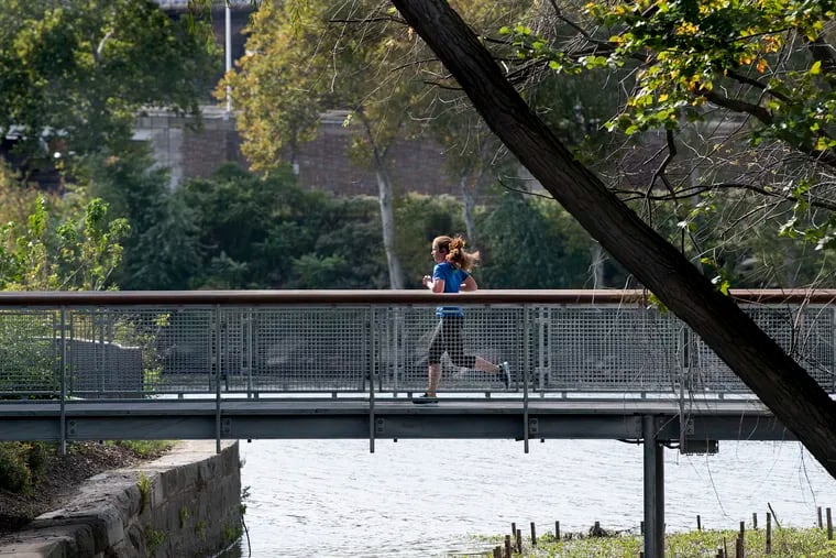 A woman runs on the bridge of the Philadelphia Parks & RecreationÕs Fairmount Water Works Boardwalk and Trail at Boathouse Row, Philadelphia, PA. Tuesday, October 16, 2018. JOSE F. MORENO / Staff Photographer