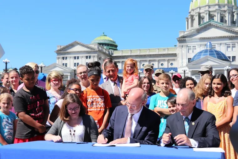 Gov. Tom Wolf signs House Bill 1324, which establishes the Military Family Education Program, at the Capitol on Monday, July 1, 2019.
