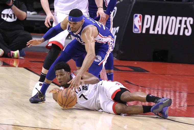 Kyle Lowry of the Raptors beats the Sixers' Tobias Harris to a loose ball.