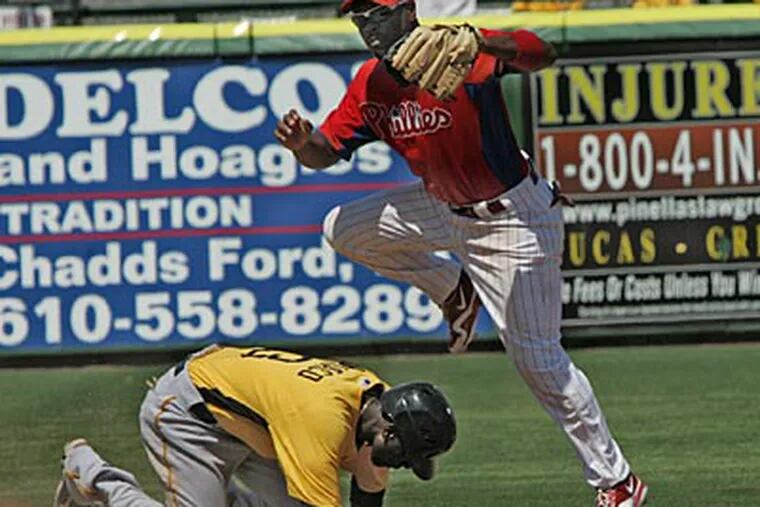 Jimmy Rollins gets airborne as he puts out Pirates Pedro Ciriaco in the fifth inning. (David M Warren / Staff Photographer)