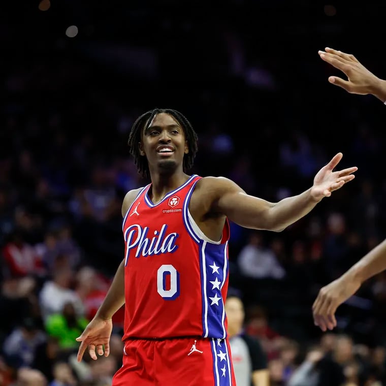 Sixers guard Tyrese Maxey receives a hand from teammate forward Tobias Harris late in the fourth quarter against the Hornets.