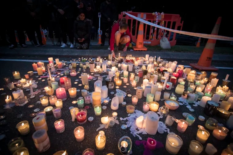 Mourners light candles, paying respects to the victims of Friday's shooting, outside the Al Noor mosque in Christchurch, New Zealand, on Monday.
