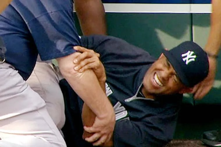 In this image taken from video, New York Yankees' Mariano Rivera,
center, grimaces after twisting his right knee shagging fly balls
during batting practice before a baseball game with the Kansas City
Royals, Thursday, May 3, 2012, in Kansas City, Mo. The Yankees closer
was later carted off the field and sent for further tests. (AP
Photo/YES Network)