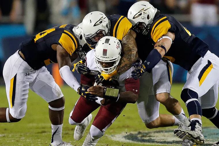 Temple's P.J. Walker gets stopped by Toledo defenders.