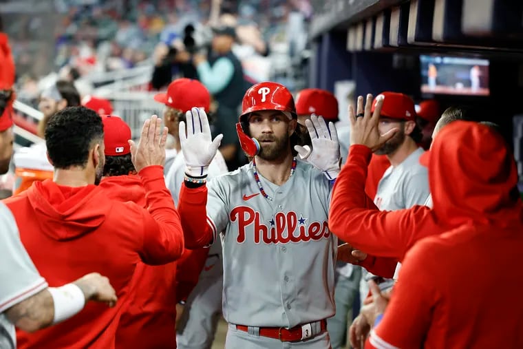 Phillies first baseman Bryce Harper celebrates his solo home run with his teammates during Game 1 of  the National League Division Series in Atlanta.