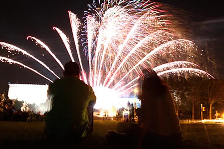 Phil and Denise Riehl watch the fireworks over the Philadelphia Museum of Art Sunday night. (David Swanson / Staff)