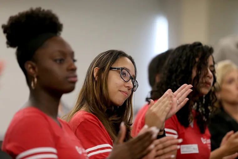 Students, including Ashley Pena (center), 19, of Camden, attend an announcement that will provide Camden youth with free medical-coding education and employment at Cooper University Health Care in Camden.