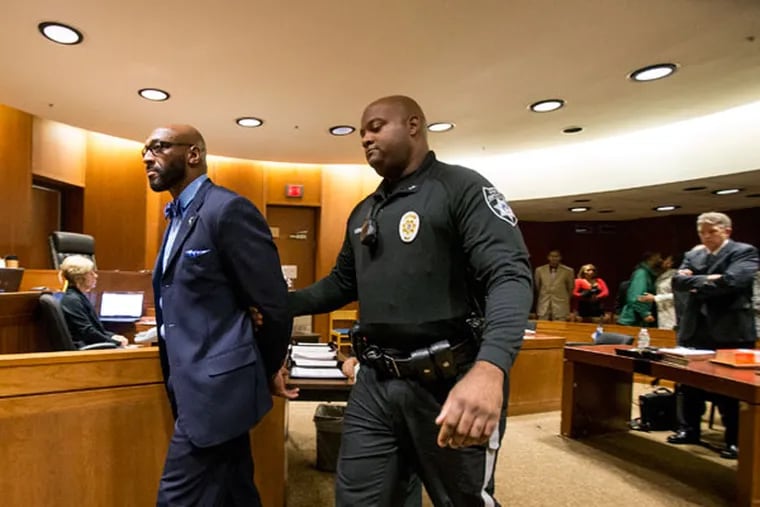 Irving Fryar is escorted from the courtroom after he was sentenced to a five-year prison term for a
mortgage scam. His mother, who also was charged, was given probation. (CHARLES FOX/Staff Photographer)