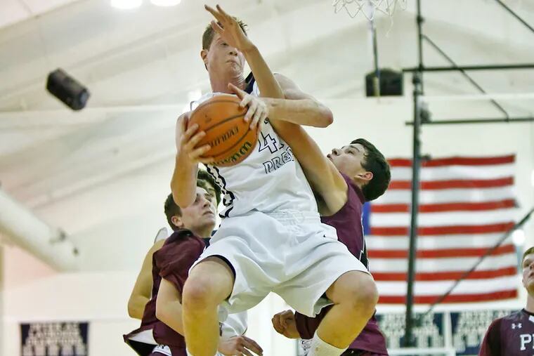 Chris Montie (right) of St. Joseph's Prep can't prevent Malvern Prep's Mike Hollingsworth from skying for an offensive rebound in the fourth quarter. St. Joe's Prep went on to win, 51-46, Friday in a nonleague boys’ basketball game at Malvern.
