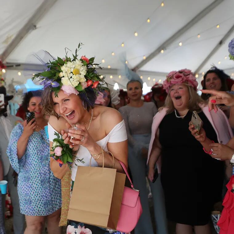 Kamila Jodzio (center) reacts to winning the “Best Blooming Hat” category in the hat contest.