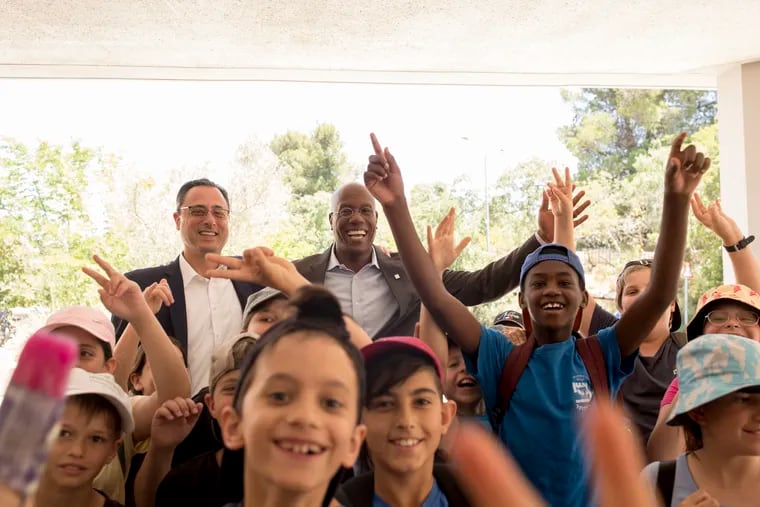 Temple University president Jason Wingard (back right) and Temple provost Gregory Mandel (back left) are greeted by children at Hebrew University in Jerusalem, during a recent visit to the Middle East.