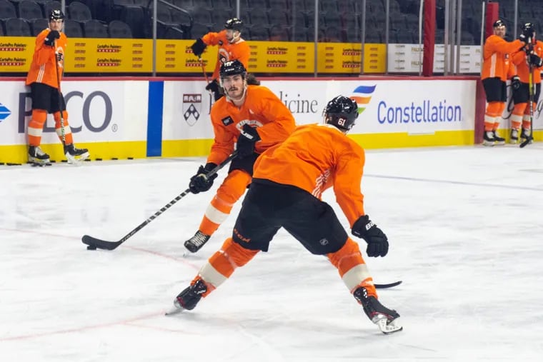 Zack MacEwen (17) faces off against Justin Braun (61) at Flyers morning skate ahead of their game against the Edmonton Oilers on Tuesday, Mar. 1, 2022.
