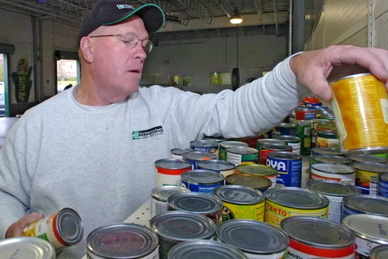 Andy Zonay inspects canned goods at the Food Bank of South Jersey for food-pantry supplies.