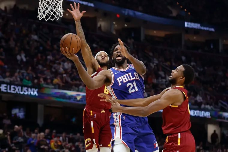 Joel Embiid (21) shoots against the Cleveland Cavaliers' Evan Mobley (4) and Lamar Stevens (8) during the second half.