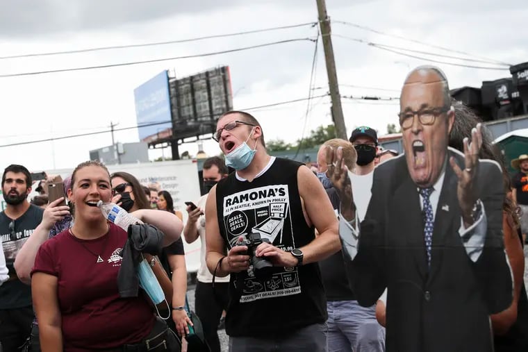 Concertgoers sing and dance next to a cutout of Rudy Giuliani while Laura Jane Grace performs during a concert at Four Seasons Total Landscaping in Northeast Philadelphia on Saturday.