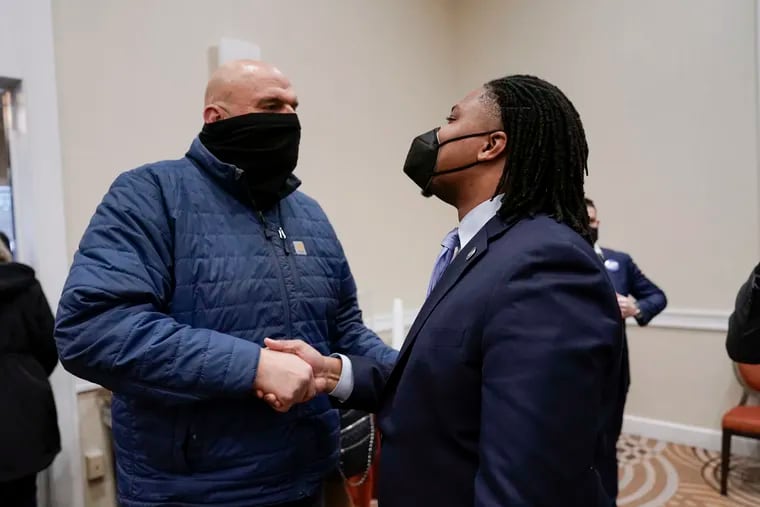 Pennsylvania Lt. Gov. John Fetterman, left, and State Rep. Malcolm Kenyatta, right, both Democratic candidates for Senate,  shake hands during a meeting of the Democratic State Committee in Harrisburg on Saturday. U.S. Rep. Conor Lamb won the most votes from committee members, but no candidate reached the two-thirds threshold needed for a formal party endorsement.