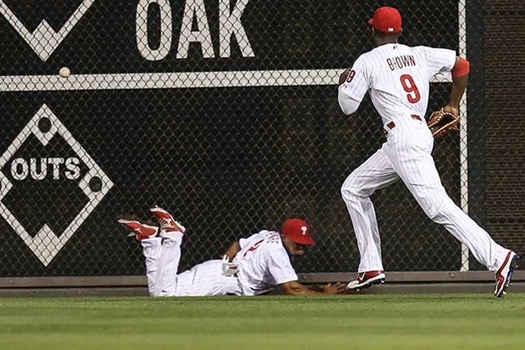 The Phillies' Ben Revere and Domonic Brown can't get a glove on triple to deep center field by Brewers' Hernan Perez during the 2nd inning at Citizens Bank Park in Philadelphia, Tuesday, June 30, 2015. ( Steven M. Falk / Staff Photographer )