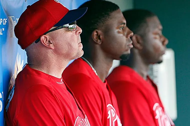 Phillies' hitting instructor Wally Joyner sits in the dugout with players John Mayberry, Jr., and Ryan Howard during a spring training intrasquad game. (Yong Kim/Staff Photographer)